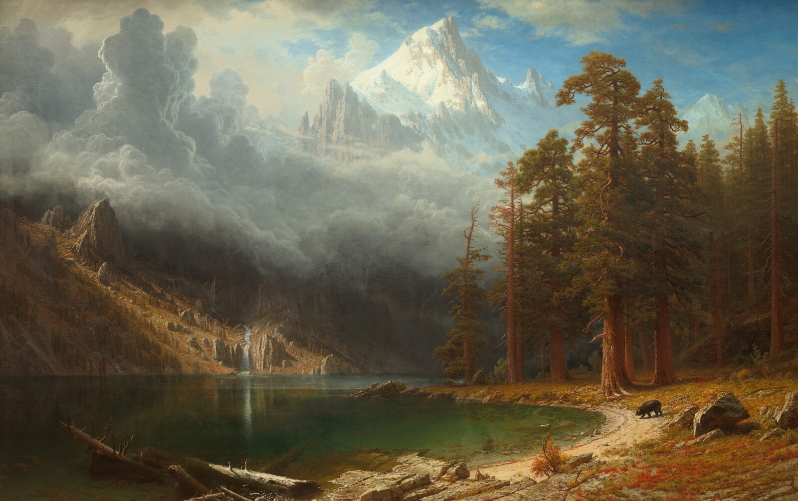 A high Sierra lake below a snow-covered peak and gathering clouds