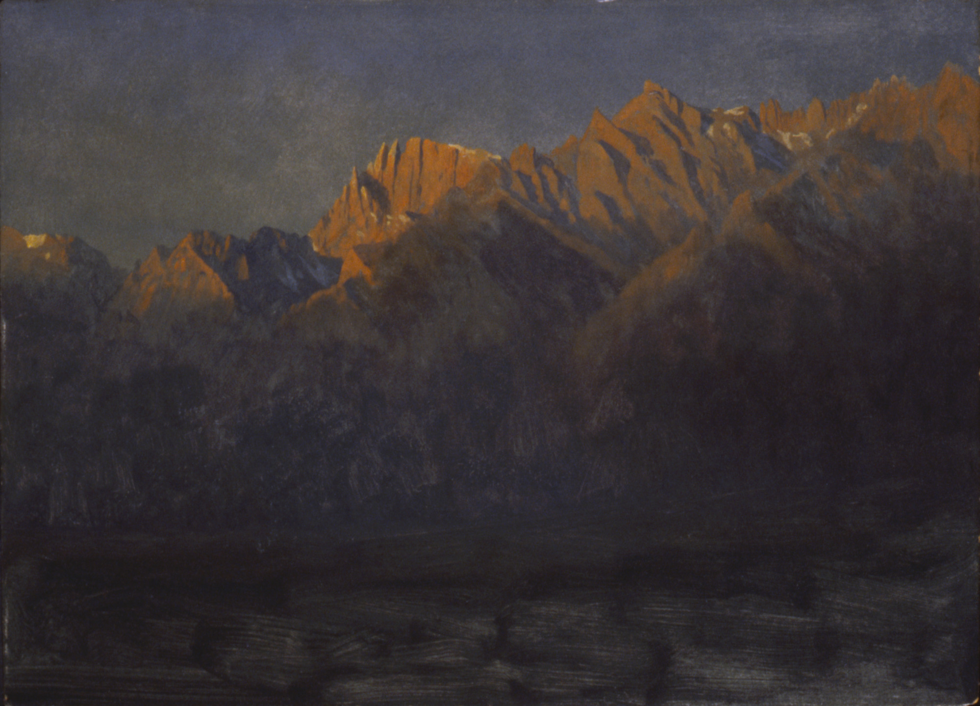 Dark Sierra peaks catching the first amber light of sunrise